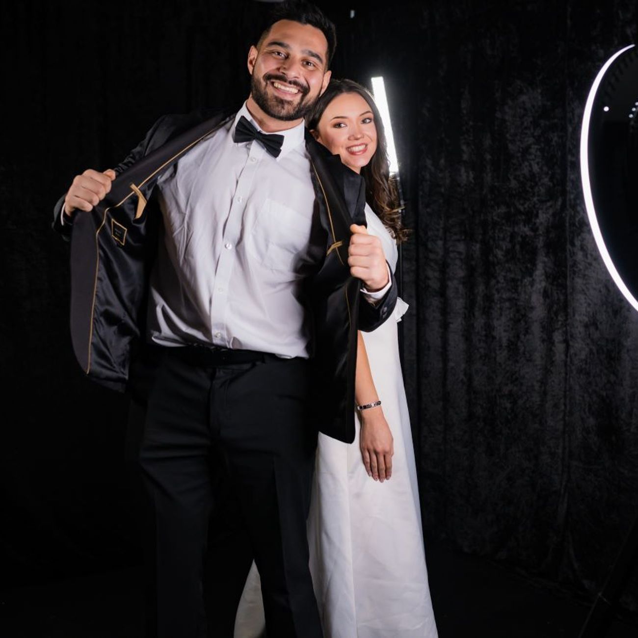 Bride and groom posing for a 360 video booth, ring light visible to the right