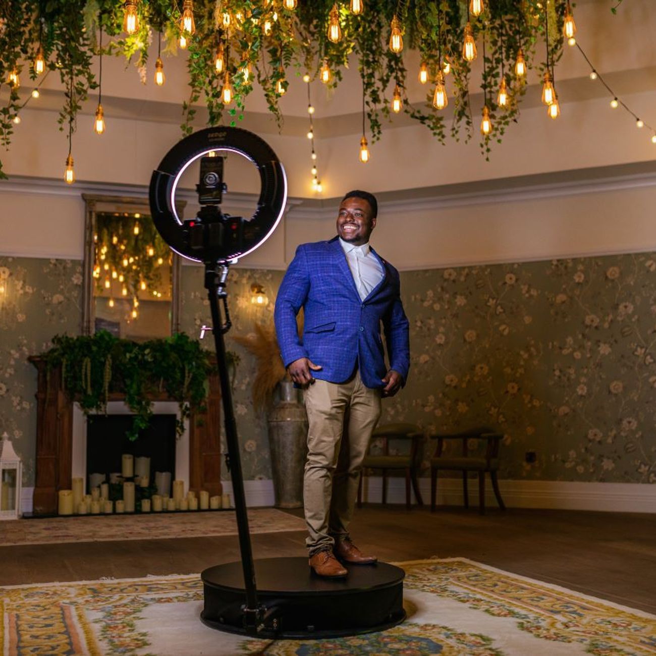 Guest on the 360 video booth platform at a luxury venue under hanging Edison bulb lighting
