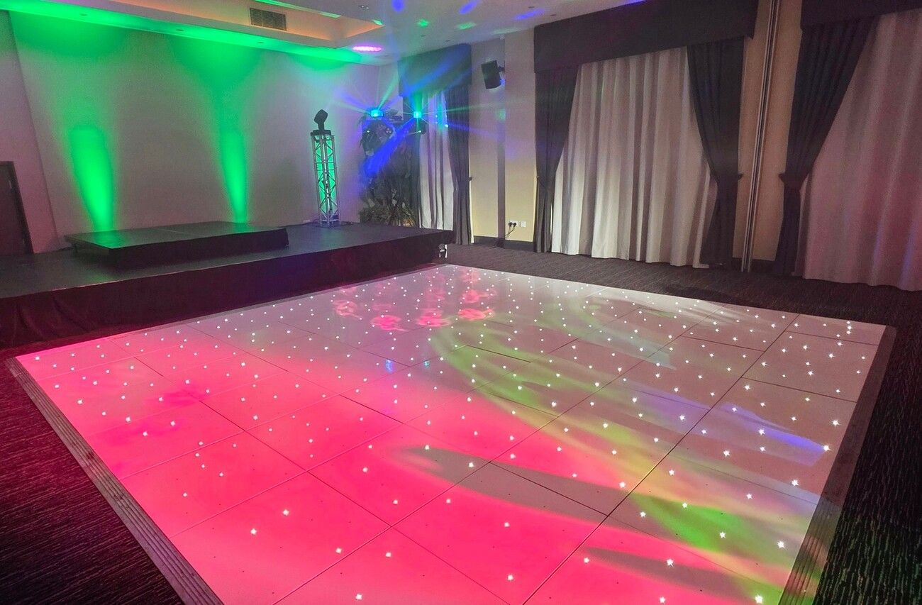 Our white starlit LED dance floor set up in the party room with the stage and lighting behind