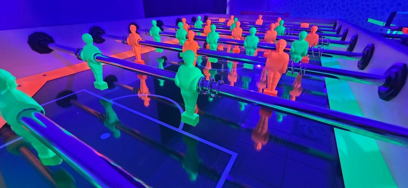Close-up of the glowing orange and green players on our UV table football table