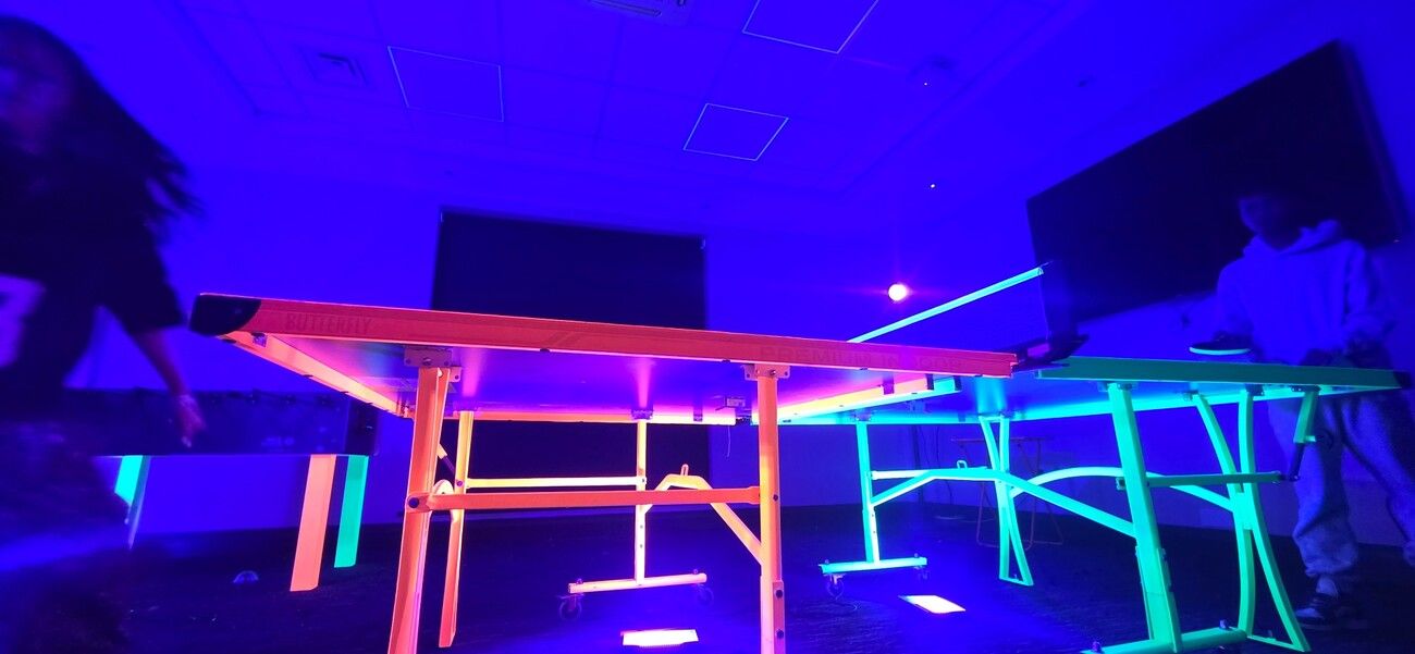 Our UV table tennis and table football tables glowing orange and green under blacklight
