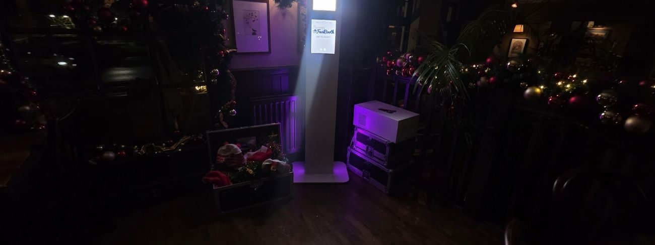 Guests using a selfie pod photo booth at a Christmas party at The Drummond