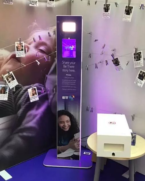 Floor-mounted photo booth — BT-branded freestanding totem in a corporate setting