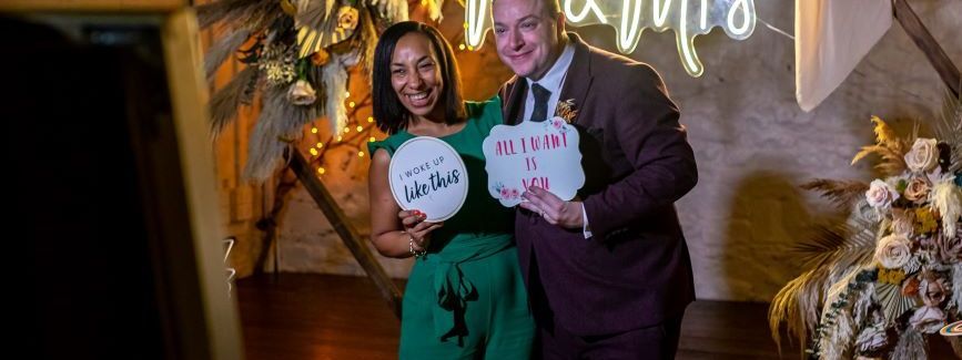 A magic mirror photo booth at a rustic barn wedding with a Mr and Mrs neon sign