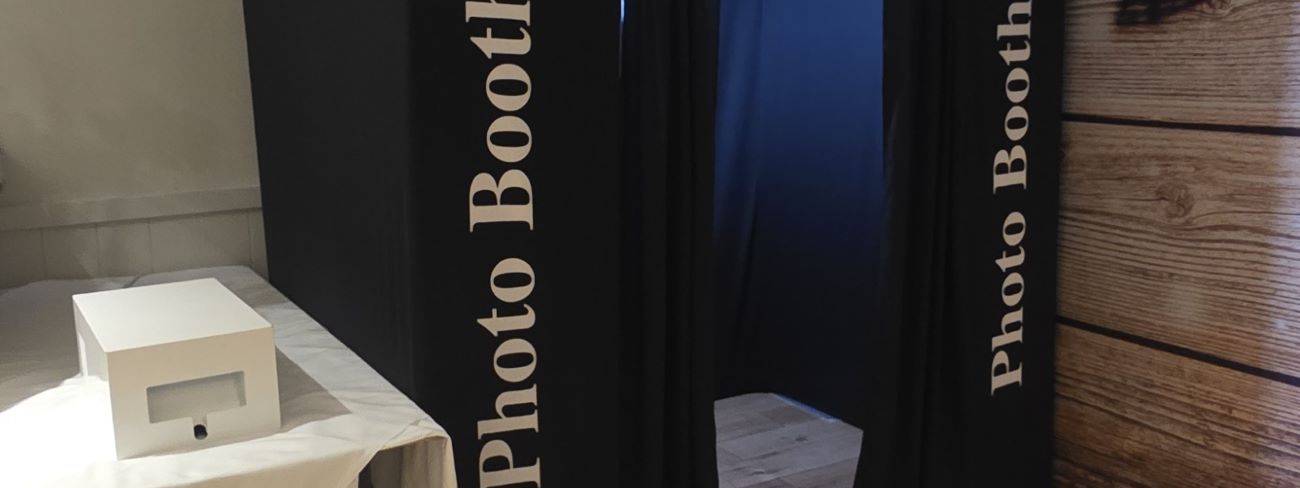 A party booth photo booth set up with a festive backdrop for a Christmas party