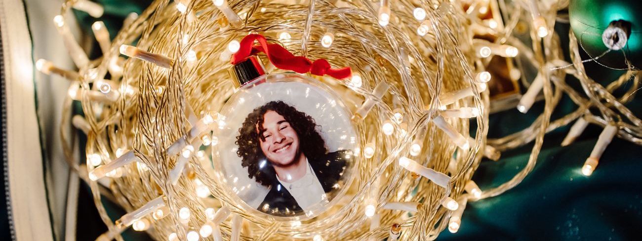 A clear photo bauble with a guest's booth photo inside, nestled in warm white fairy lights