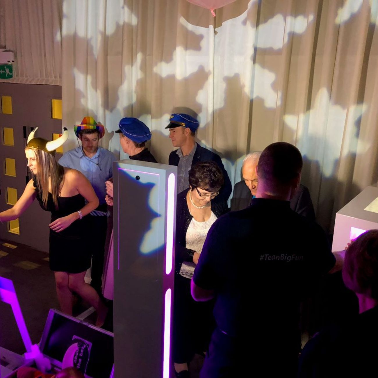 Twin selfie pods set up side by side at a corporate team-building event with star projection lighting, guests in viking, police and rainbow hats