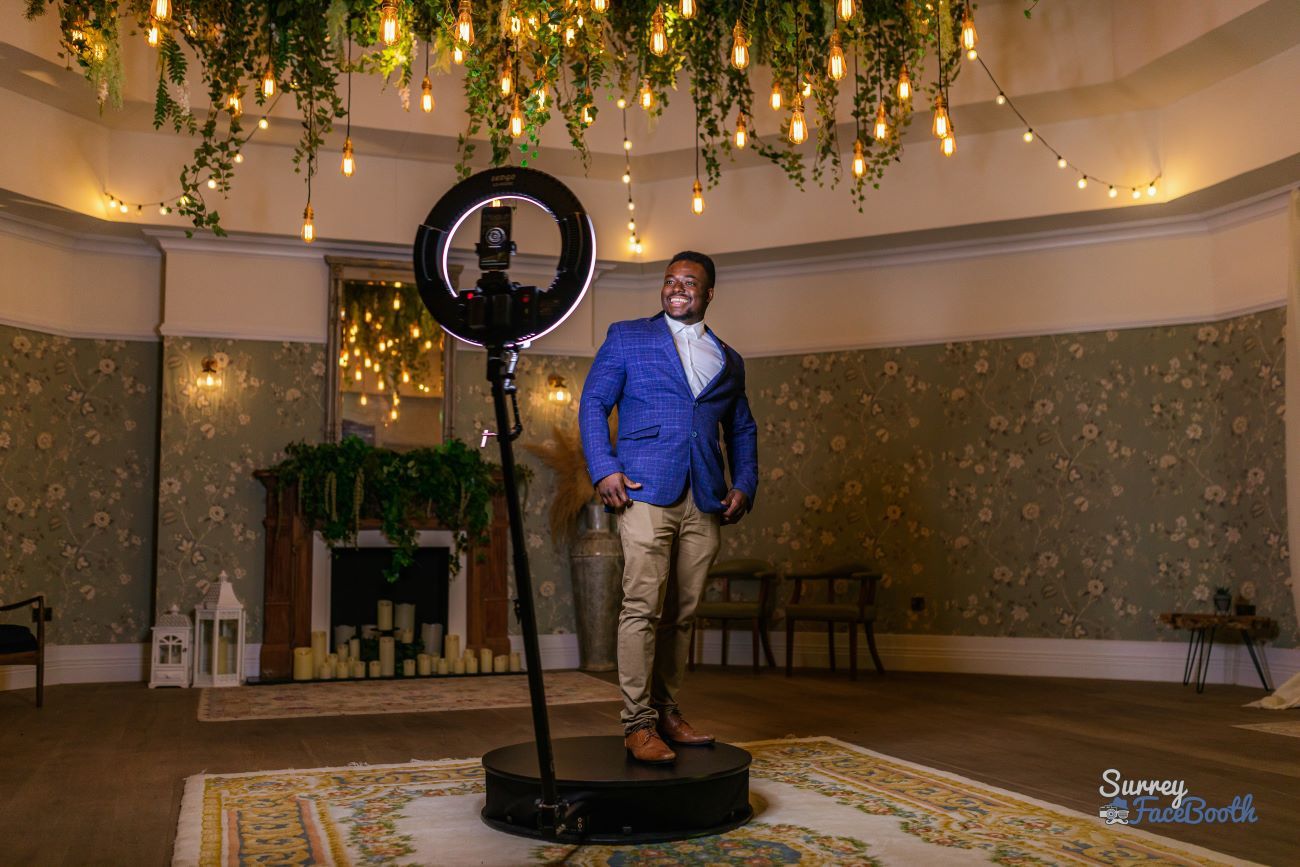 Guest on the 360 video booth platform at a luxury venue under hanging Edison bulb lighting