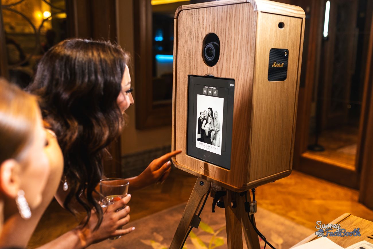 Bride tapping the share screen on the vintage photo booth after a Kardashian Glam capture — black-and-white group portrait on screen, ready to send via QR, email or text