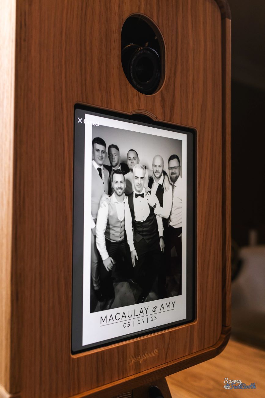 Vintage photo booth touchscreen running the Kardashian Glam experience — black-and-white studio-lit group portrait branded 'Macaulay & Amy 05|05|23'
