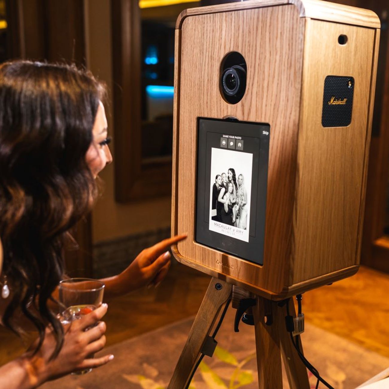 Bride tapping the share screen on the vintage photo booth after a Kardashian Glam capture — black-and-white group portrait on screen, ready to send via QR, email or text