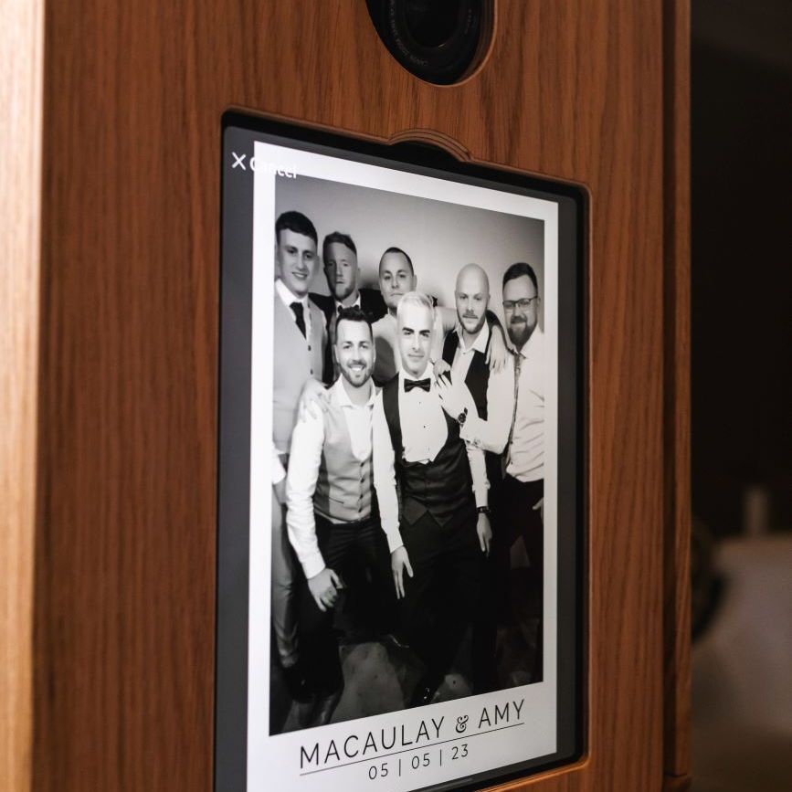 Vintage photo booth touchscreen running the Kardashian Glam experience — black-and-white studio-lit group portrait branded 'Macaulay & Amy 05|05|23'